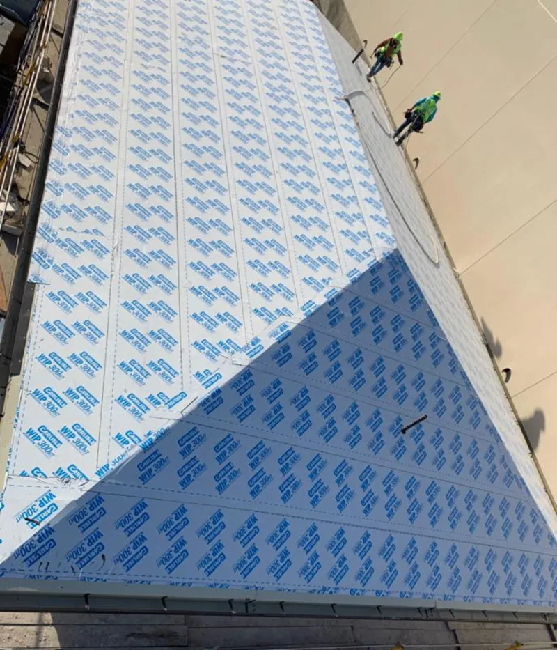 Professional roofers installing underlayment on a metal roof in Wellington